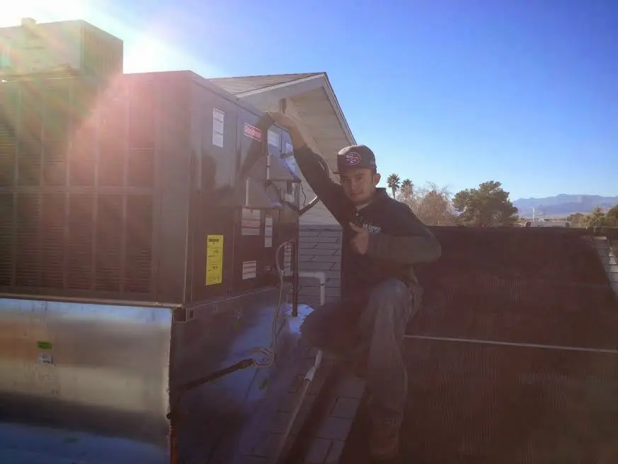 HVAC technician performing AC Tune-Up on a rooftop unit in Rochelle Park